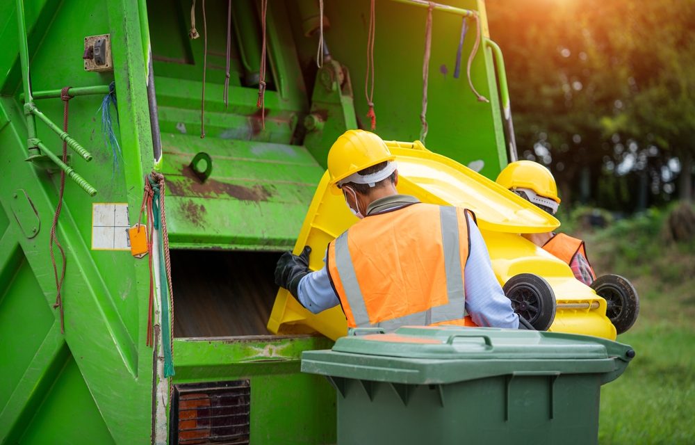 Commercial waste disposal by waste collectors into a truck