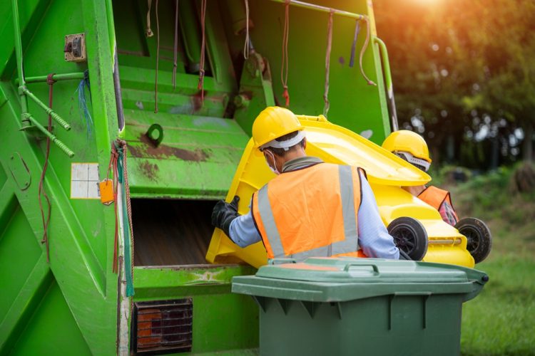 Commercial waste disposal by waste collectors into a truck